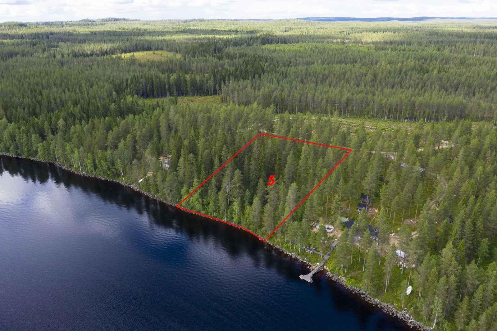Tontin kaava piirrettynä kesäisen metsän ylle järven rantaan. Naapuritontilla on mökki. Ilmakuva.