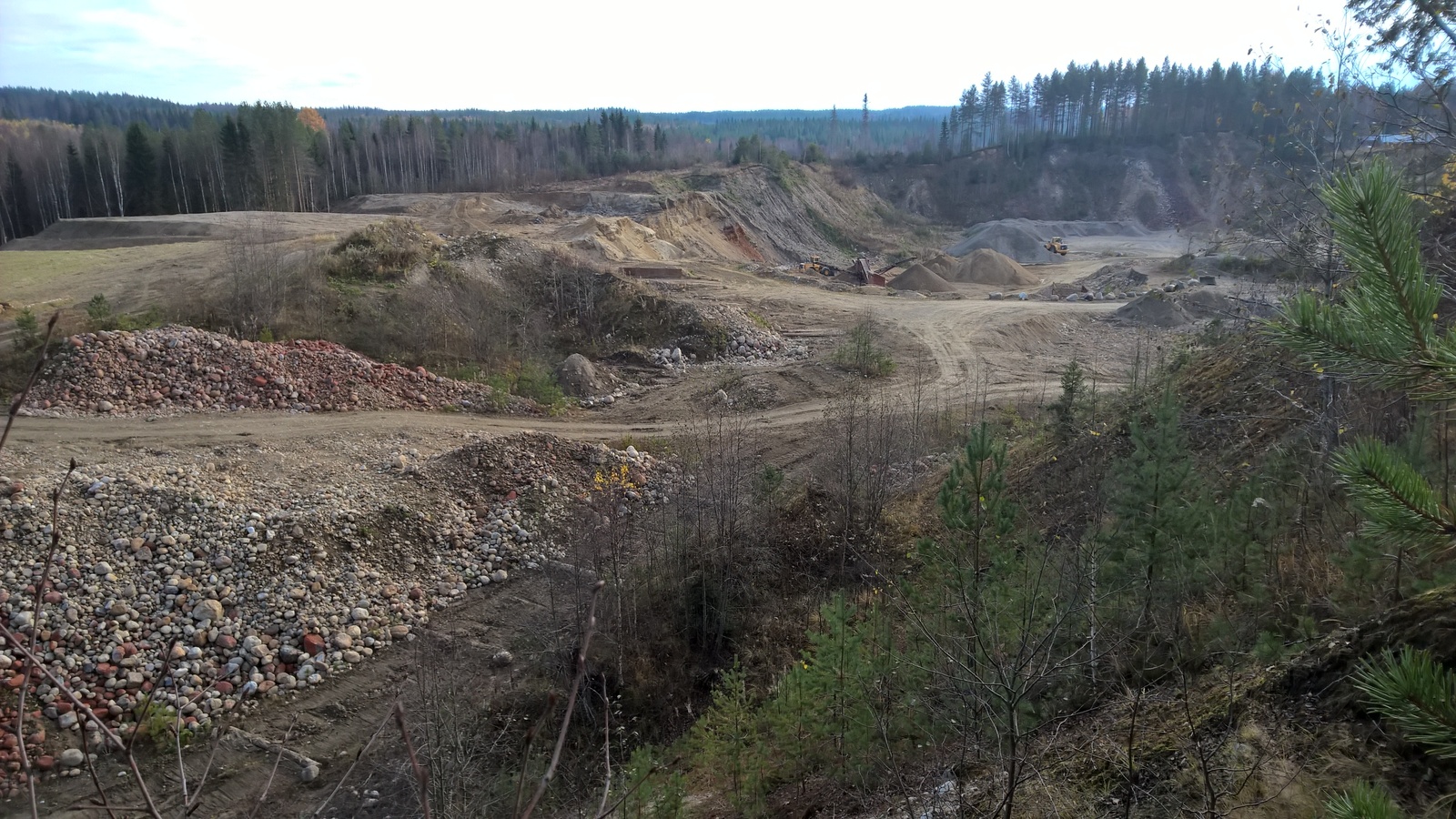 Tontin takarajan toisella puolella sijaitsee soramonttu. Montussa on kaksi traktoria.