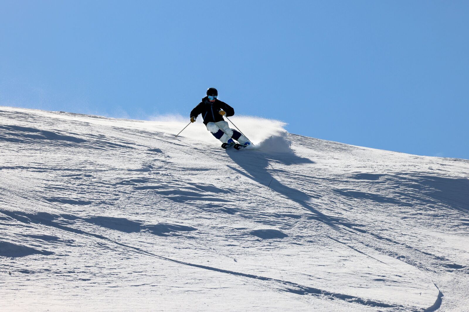 Henkilö laskettelee vauhdikkaasti tunturin rinteellä.
