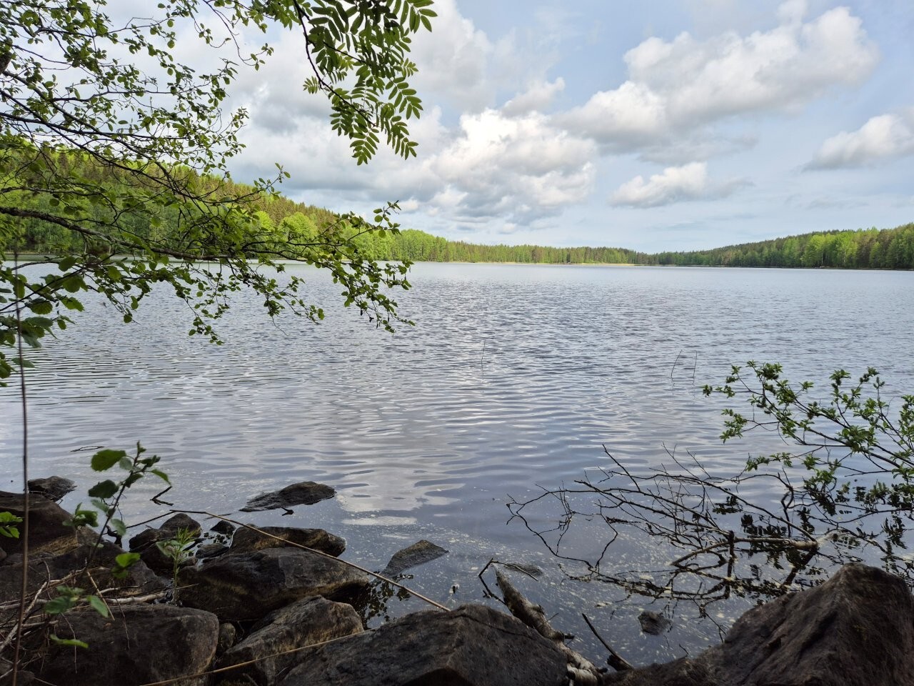 Näkymä järvelle, ranta etualalla on kivikkoinen.