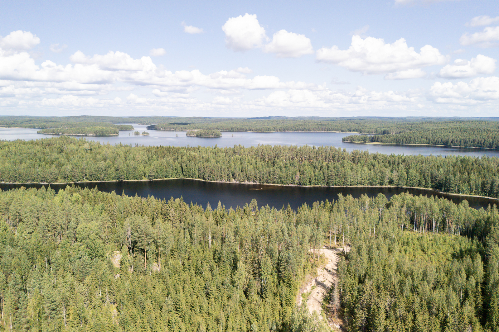 Ilmakuva jossa etualalla on tonttitie, seuraavana tummana näkyvä Pirttisalmi ja sitten Pirttisaari.