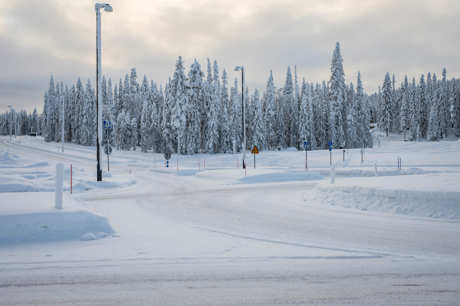 Talvinen maisema. Liikenneympyrän takana olevalla tontilla kasvaa kuusia.