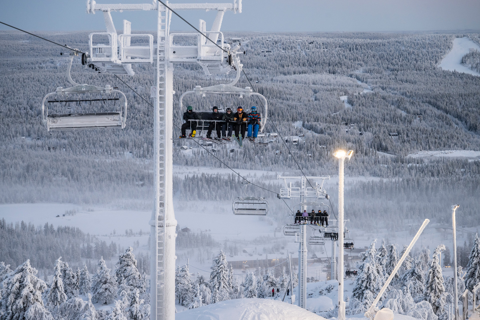 Laskettelukeskuksen tuolihississä nouse ihmisiä tunturin laelle.