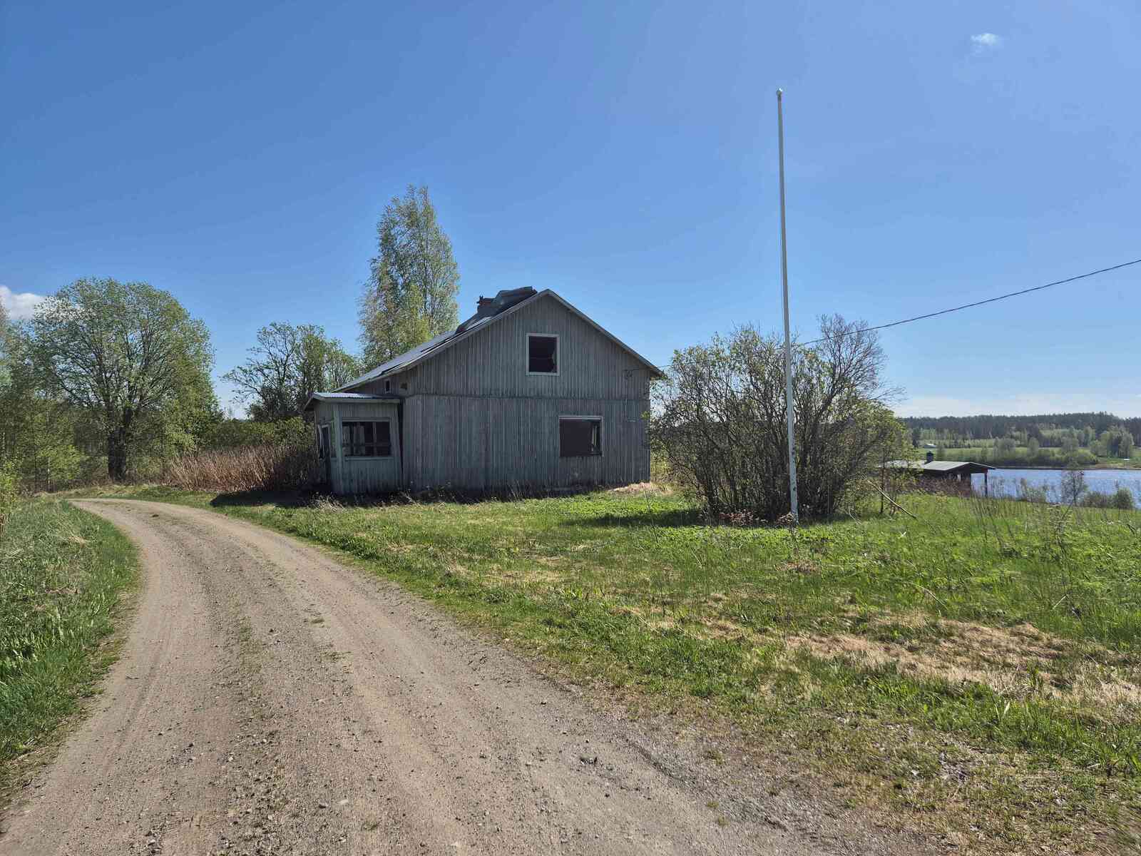Vanha maatalo jonka peltikatto on jo rullalla ja kuisti notkahtanut.