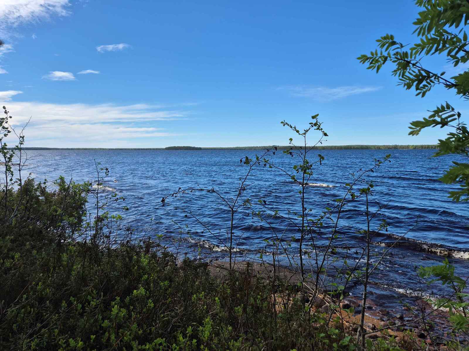 Vaahtopäinä laineileva Laakajärvi, taivalla on hentoisia pilviä, kaukana näkyy vastaranta.