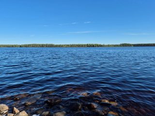 Maisema järvelle, ranta on kivikkoinen, vastaranta näkyy kaukaisuudessa.