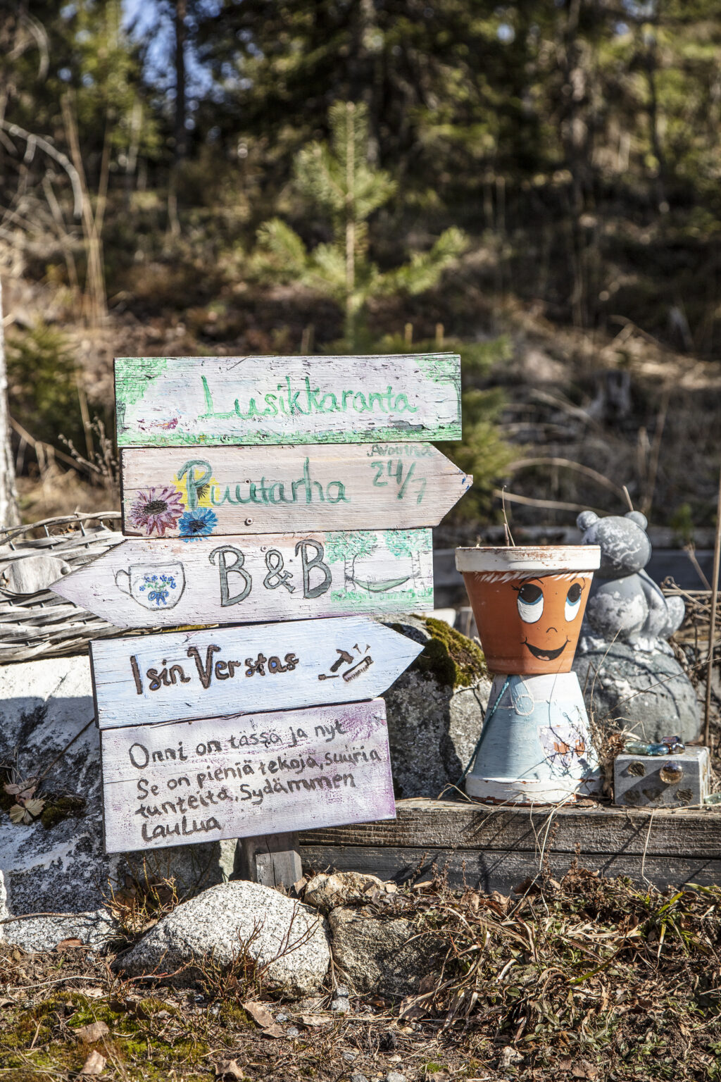 Iloisia opasteita mökin pihamaalla.